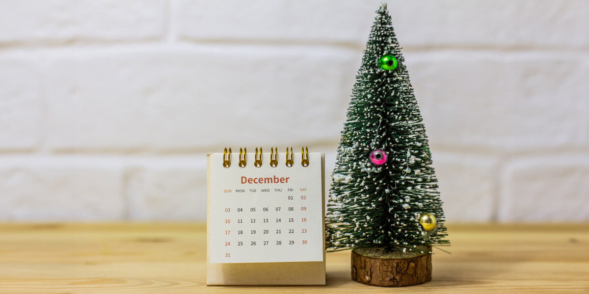 A festive calendar with a Christmas tree and a small tree, spreading holiday cheer.