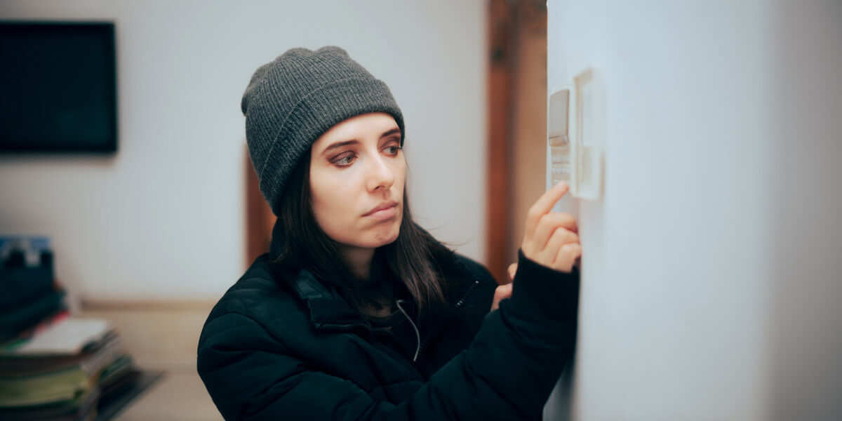 A woman wearing a beanie gazes at a wall, captivated by its presence.