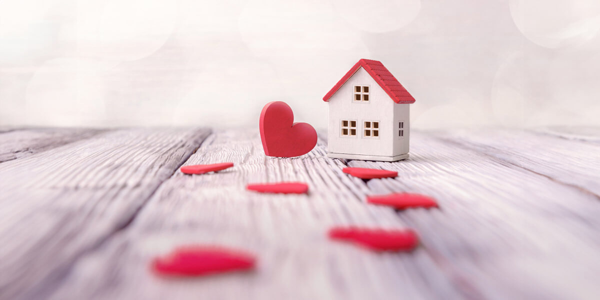 A heart-shaped house on a wooden table, symbolizing love and home.